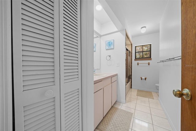 full bathroom featuring toilet, a closet, tile patterned floors, combined bath / shower with glass door, and vanity