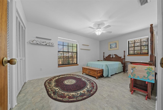 bedroom with baseboards, visible vents, multiple windows, and a closet