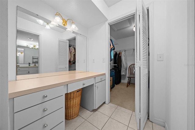 bathroom with tile patterned floors, a spacious closet, and vanity