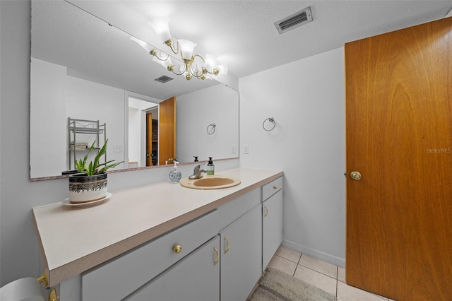 bathroom featuring tile patterned flooring, an inviting chandelier, vanity, and visible vents