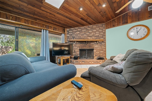 living area featuring visible vents, wooden ceiling, a fireplace, ceiling fan, and vaulted ceiling