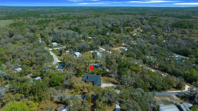 bird's eye view with a wooded view