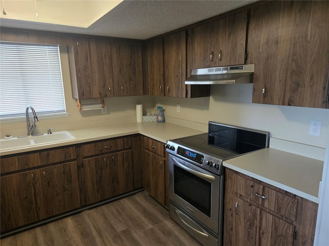 kitchen featuring light countertops, stainless steel range with electric cooktop, a sink, and under cabinet range hood