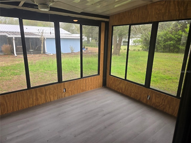 unfurnished sunroom with lofted ceiling, a healthy amount of sunlight, and ceiling fan