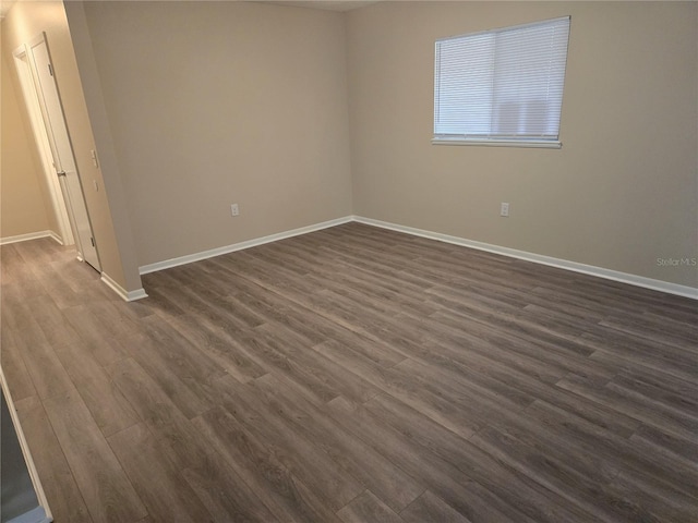 unfurnished room featuring dark wood finished floors and baseboards