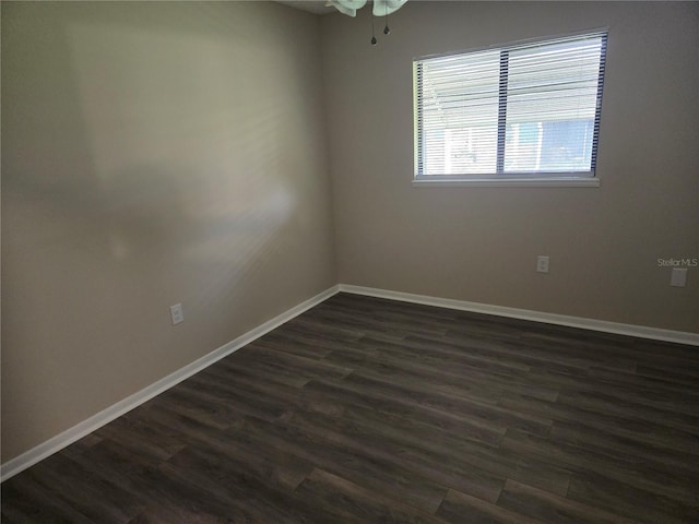 spare room with dark wood finished floors and baseboards