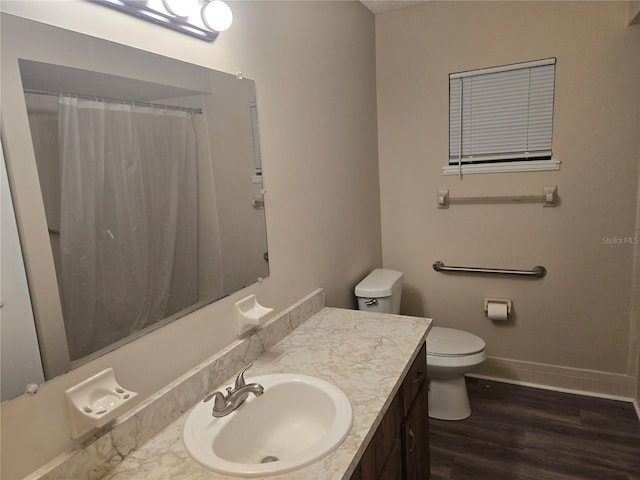 full bath featuring toilet, a shower with shower curtain, wood finished floors, vanity, and baseboards