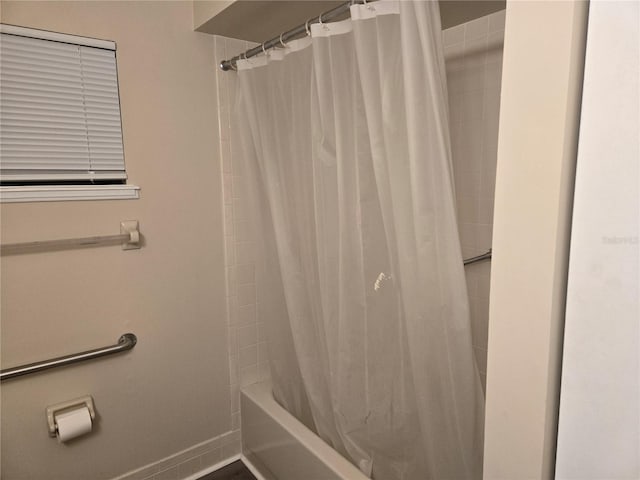 full bath featuring shower / tub combo and baseboards