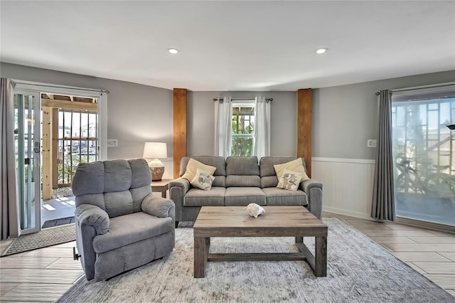 living room with recessed lighting, wood finished floors, and a wainscoted wall