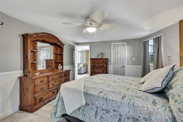 bedroom featuring a wainscoted wall, a closet, and ceiling fan