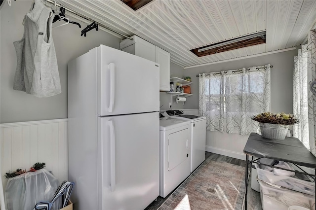 laundry room with light wood finished floors, independent washer and dryer, wainscoting, and laundry area