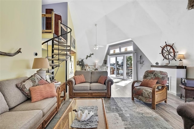 living room featuring stairs, high vaulted ceiling, wood finished floors, and a ceiling fan