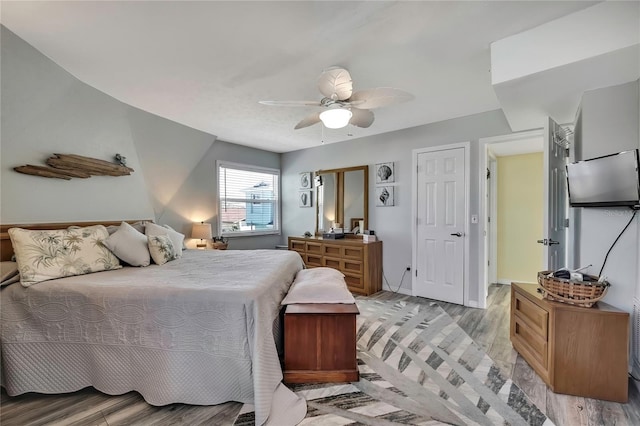 bedroom with a ceiling fan, light wood-style floors, and baseboards