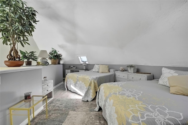 bedroom featuring lofted ceiling and wood finished floors