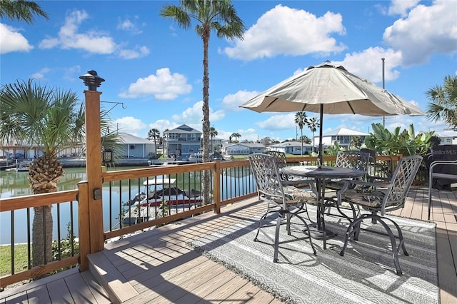 deck featuring outdoor dining area, a residential view, and a water view