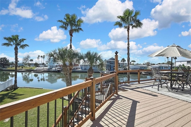 wooden deck featuring a lawn and a water view