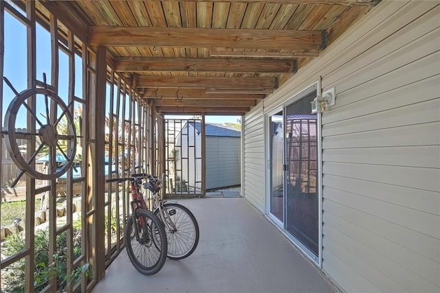 unfurnished sunroom featuring beamed ceiling and wood ceiling