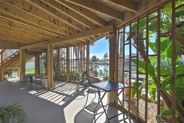 unfurnished sunroom featuring a water view