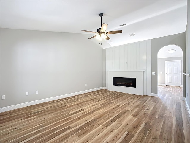 unfurnished living room featuring light wood-style floors, visible vents, vaulted ceiling, and a ceiling fan