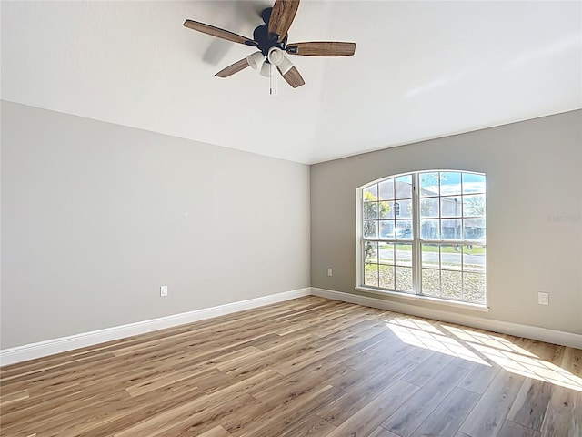 spare room featuring light wood-style floors, baseboards, and a ceiling fan