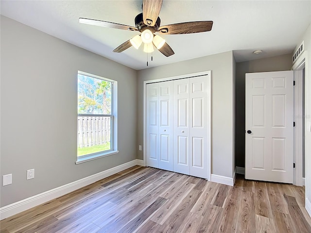 unfurnished bedroom with a closet, visible vents, baseboards, and light wood finished floors