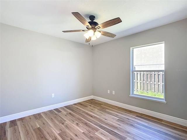 spare room with a ceiling fan, baseboards, and wood finished floors