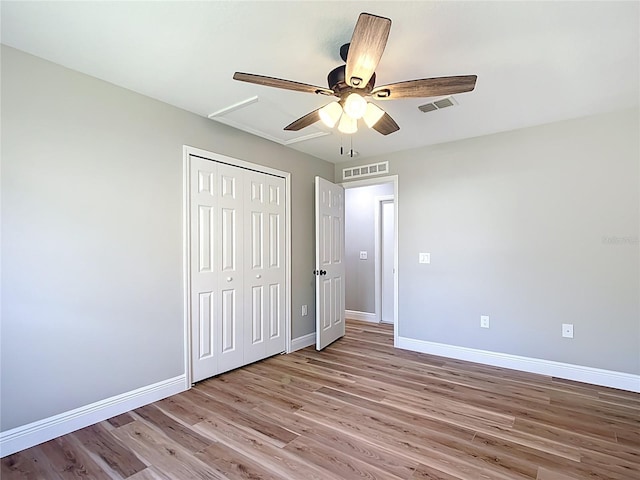 unfurnished bedroom with light wood-style floors, a closet, visible vents, and baseboards