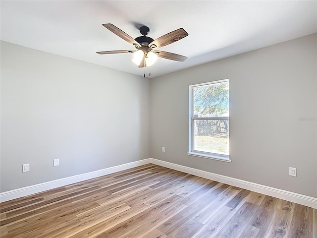 empty room featuring ceiling fan, light wood-style flooring, and baseboards