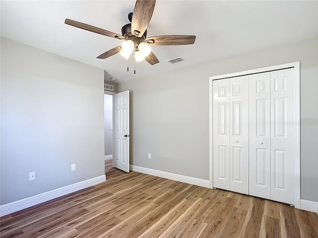 unfurnished bedroom with ceiling fan, visible vents, baseboards, a closet, and light wood finished floors