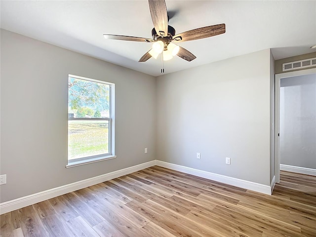 unfurnished room with light wood-style floors, baseboards, visible vents, and ceiling fan