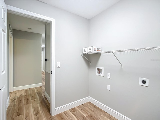 clothes washing area featuring laundry area, baseboards, light wood-style flooring, hookup for an electric dryer, and washer hookup