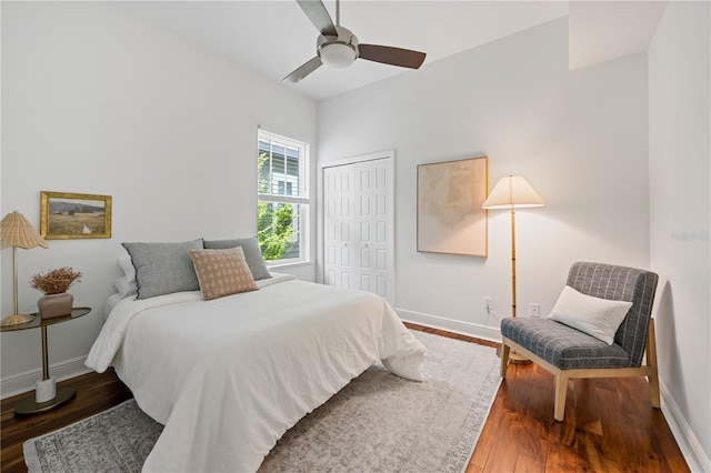 bedroom with a closet, wood finished floors, a ceiling fan, and baseboards