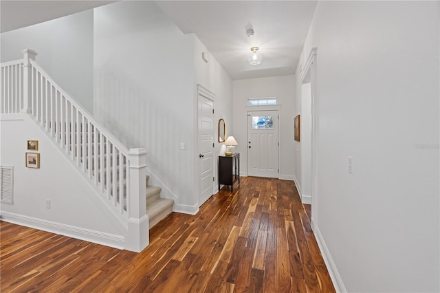 entrance foyer with stairs, visible vents, hardwood / wood-style flooring, and baseboards