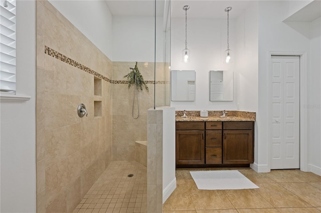 bathroom featuring baseboards, walk in shower, vanity, and tile patterned floors