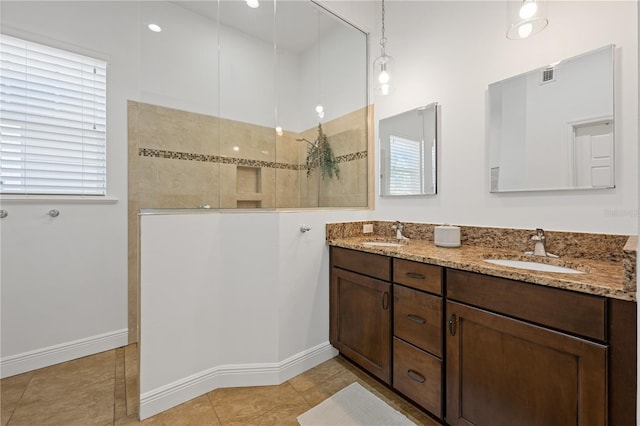 bathroom featuring a walk in shower, tile patterned flooring, a sink, and visible vents