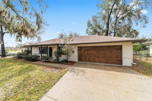 ranch-style house featuring brick siding, a front lawn, fence, concrete driveway, and an attached garage