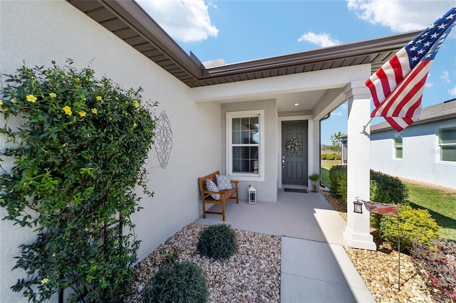 doorway to property with stucco siding and a porch