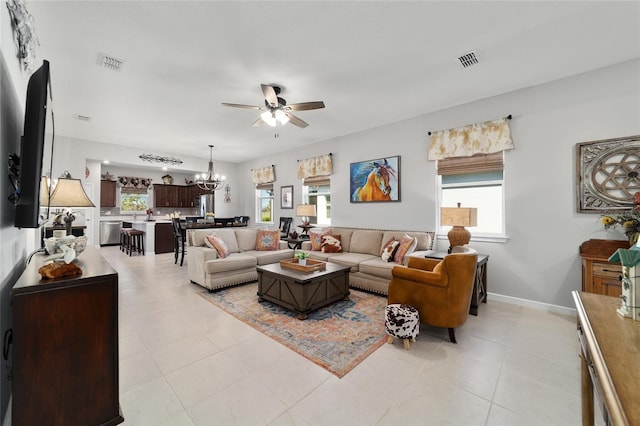 living area featuring visible vents, a healthy amount of sunlight, and ceiling fan with notable chandelier