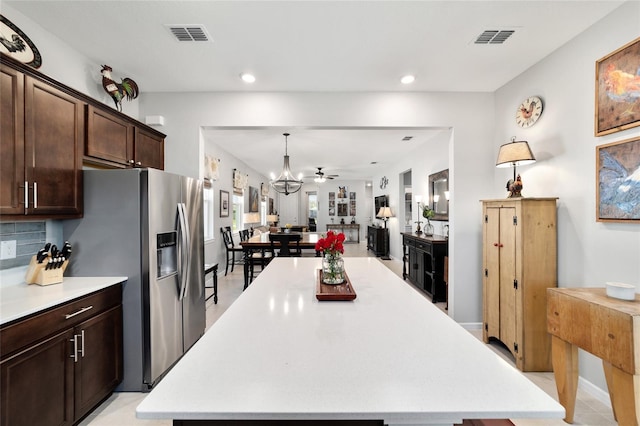 kitchen with light countertops, open floor plan, dark brown cabinets, and visible vents