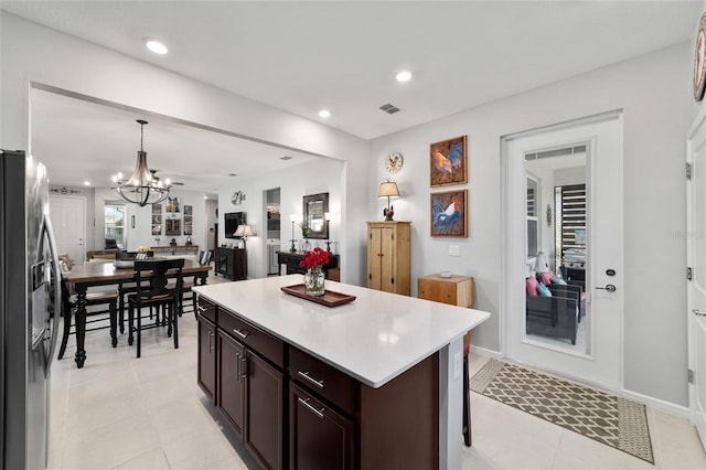 kitchen with dark brown cabinets, open floor plan, light countertops, recessed lighting, and stainless steel fridge