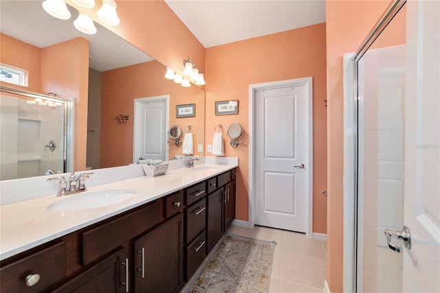 bathroom featuring a sink, a shower with door, double vanity, and tile patterned flooring