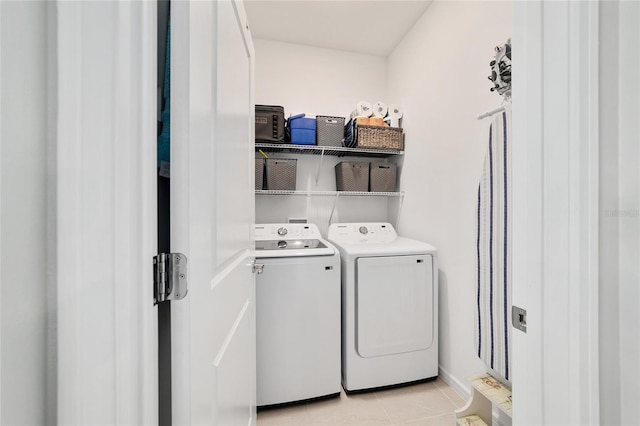 laundry room featuring light tile patterned floors, laundry area, and washer and clothes dryer