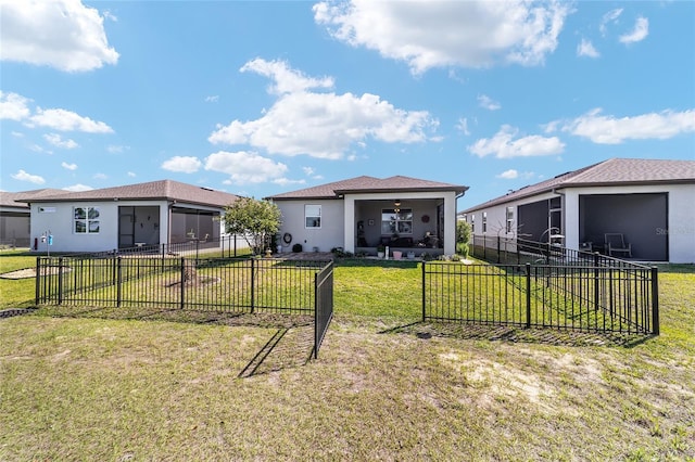 view of front of property featuring a front yard, fence private yard, a sunroom, and stucco siding