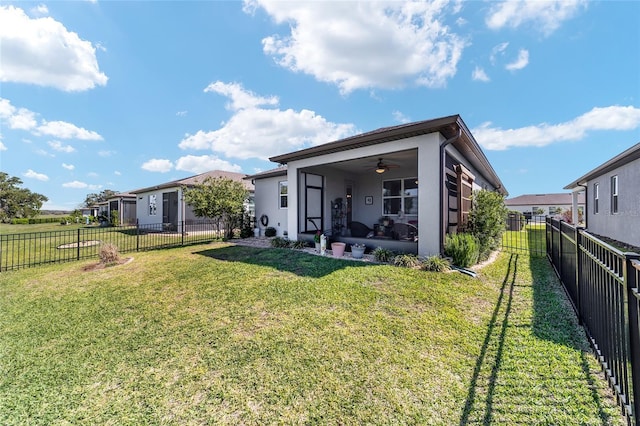 rear view of house with stucco siding, a patio, a fenced backyard, a yard, and ceiling fan