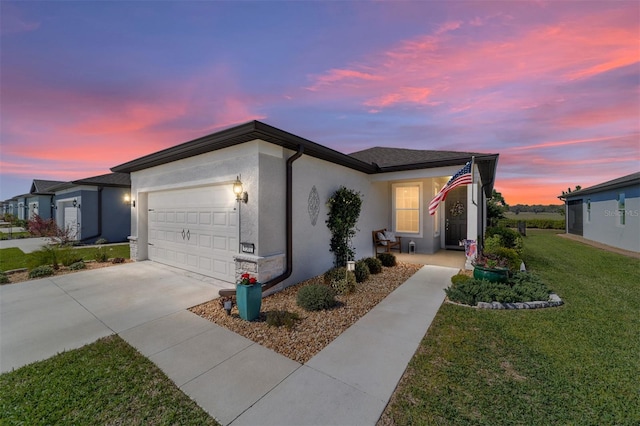 view of front of home featuring a yard, stucco siding, concrete driveway, and a garage