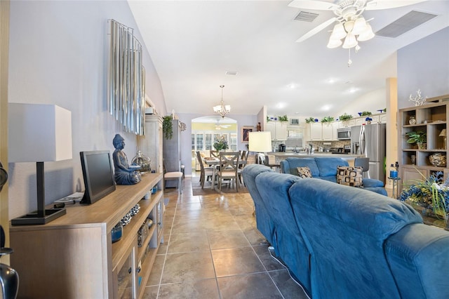 living area featuring visible vents, lofted ceiling, ceiling fan with notable chandelier, and tile patterned flooring