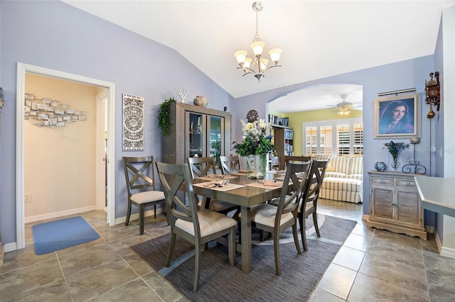 tiled dining room featuring baseboards, arched walkways, ceiling fan with notable chandelier, and vaulted ceiling