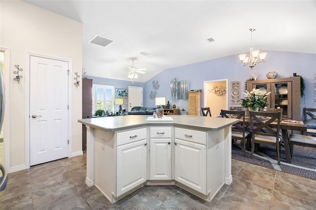 kitchen featuring visible vents, a kitchen island, vaulted ceiling, light countertops, and white cabinetry