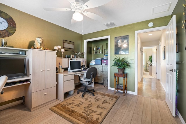 office area featuring light wood-type flooring, visible vents, baseboards, and ceiling fan