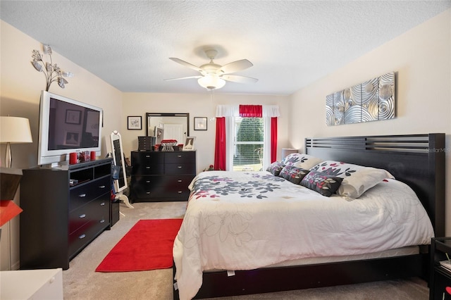 bedroom with light colored carpet, ceiling fan, and a textured ceiling